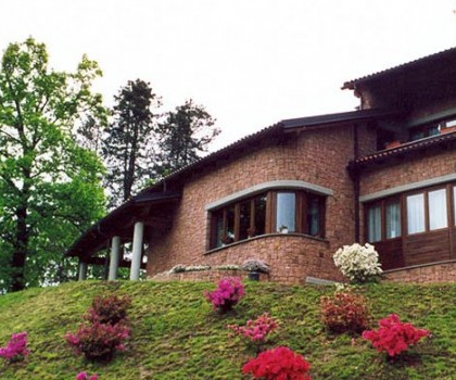 EDILIZIA RESIDENZIALE-Nuova villetta singola a Valdilana, Trivero (BI) - 1995
Questo edificio, collocato in posizione dominante in cima a una collina, ha una disposizione in pianta con una forma leggermente arcuata, in modo da privilegiare la facciata sud, dove la vista e l'esposizione sono migliori. Abbiamo realizzato la struttura in cemento armato seguendo le particolari forme della pianta dell'edificio, mentre abbiamo eseguito il rivestimento esterno con  blocchetti squadrati a mano di porfido rosso proveniente dalle cave di Cuasso al Monte (VA). A nostro avviso tutto questo ha reso l’effetto finale molto particolare. Infine, nel piano giorno è presente il giardino interno che si affaccia per mezzo di vetrate sui locali interni e prende la luce naturale dall'alto. 