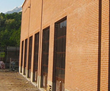 EDILIZIA INDUSTRIALE E DIREZIONALE-Realizzazione della nuova centrale termica per il lanificio Vitale Barberis Canonico S.p.A. a Trivero (BI) - 2008
La realizzazione di questo nuovo edificio ha richiesto un importante scavo di sbancamento, fino alla profondità di 6 metri, per rimuovere la porzione di terreno inadatto a ricevere i futuri carichi. Le fondazioni sono state impostate a quella profondità realizzando ulteriori pozzi di calcestruzzo per raggiungere il terreno più idoneo. Da quella profondità, lungo il perimetro, abbiamo realizzato una serie di plinti e travi di collegamento in cemento armato per poter appoggiare poi successivamente la struttura prefabbricata. Il volume di materiale rimosso è stato sostituito con del nuovo materiale di cava, avente caratteristiche decisamente migliori. L'edificio è stato rivestito completamente con mattoni a vista posati a mano, riprendendo lo stile che caratterizza i nuovi edifici dello stabilimento. Dopodiché la centrale termica è stata collegata ai vari reparti del lanificio per mezzo di un cunicolo tecnologico interrato.