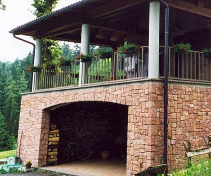 EDILIZIA RESIDENZIALE-Nuova villetta singola a Valdilana, Trivero (BI) - 1995
Questo edificio, collocato in posizione dominante in cima a una collina, ha una disposizione in pianta con una forma leggermente arcuata, in modo da privilegiare la facciata sud, dove la vista e l'esposizione sono migliori. Abbiamo realizzato la struttura in cemento armato seguendo le particolari forme della pianta dell'edificio, mentre abbiamo eseguito il rivestimento esterno con  blocchetti squadrati a mano di porfido rosso proveniente dalle cave di Cuasso al Monte (VA). A nostro avviso tutto questo ha reso l’effetto finale molto particolare. Infine, nel piano giorno è presente il giardino interno che si affaccia per mezzo di vetrate sui locali interni e prende la luce naturale dall'alto. 