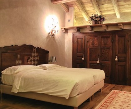 EDILIZIA TURISTICO-RICETTIVA-Demolizione dell’edificio esistente e realizzazione di un nuovo edificio adibito a Chambre d'Hotes nel centro di Aosta - 2012
Abbiamo completamente demolito l’edificio e lo abbiamo ricostruito dalle fondazioni con tecniche edilizie all'avanguardia. La struttura è in cemento armato antisismica e le fondazioni sono totalmente svincolate dal terreno per mezzo di pannelli isolanti in fibra di vetro ad alta resistenza meccanica. Abbiamo realizzato i tamponamenti utilizzando blocchi di argilla per garantire un isolamento acustico, mentre l'isolamento a cappotto è stato fatto con pannelli di lana minerale abbinando all'isolamento termico anche un elevato isolamento acustico. I serramenti, in legno lamellare assemblato, sono in abete all’esterno e in larice termico evaporato all’interno, con triplo vetro doppia camera basso emissivo. La copertura in legno termo-trattato (travi e tavolato) è caratterizzata da teli di tenuta all’aria, isolamento termico in fibra di legno, lamiera e finitura in lose di serpentino. Le finiture interne sono state eseguite con pavimenti in legno controbilanciato in larice termico, con finitura in loco a base di olio e cera, mentre gli intonaci degli interni con una finitura anticata dalle manualità uniche. L’impianto di riscaldamento è misto: radiatori nelle camere e a pavimento radiante nelle parti comuni, mentre in salotto c’è un termocamino a legna. Infine, l’impianto elettrico è stato progettato con un sistema di domotica, che consente la gestione a distanza di tutta la struttura.
